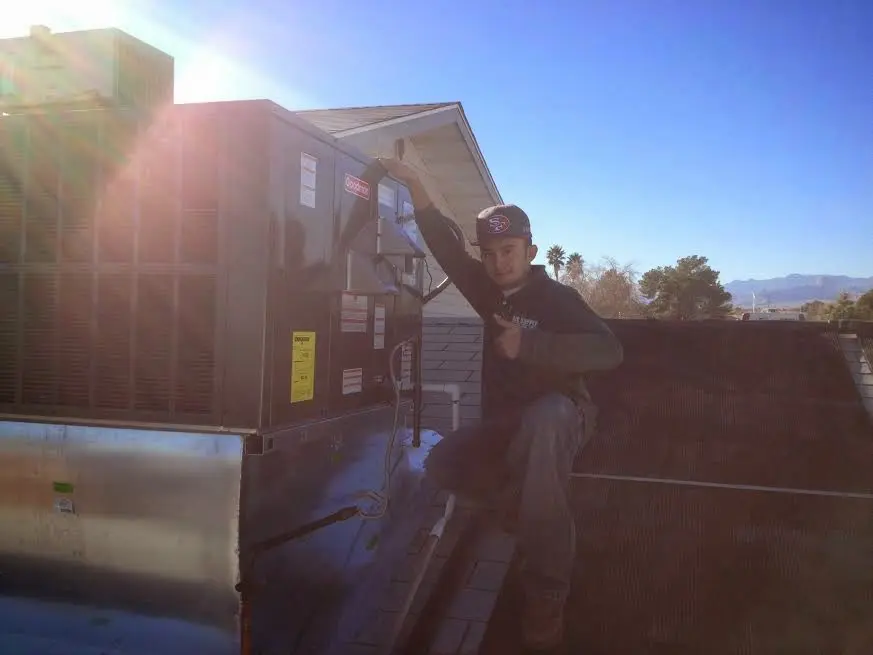 HVAC technician performing HVAC Inspection on a rooftop unit in St. Peters